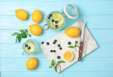 Photo of Flat lay composition with delicious natural lemonade on color background