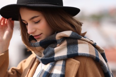 Photo of Beautiful woman in warm scarf and hat outdoors