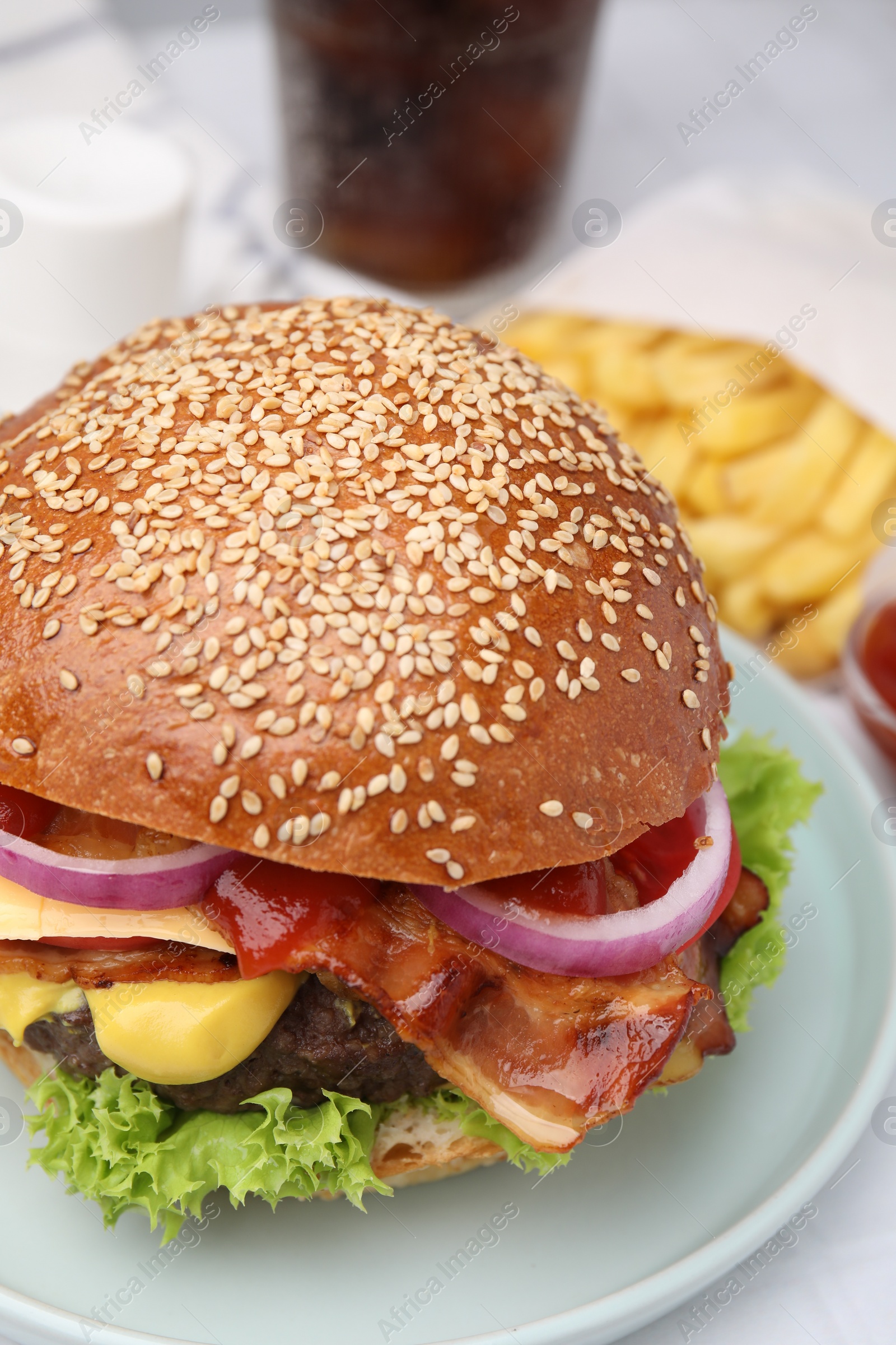 Photo of Delicious burger with bacon, patty and vegetables on table, closeup