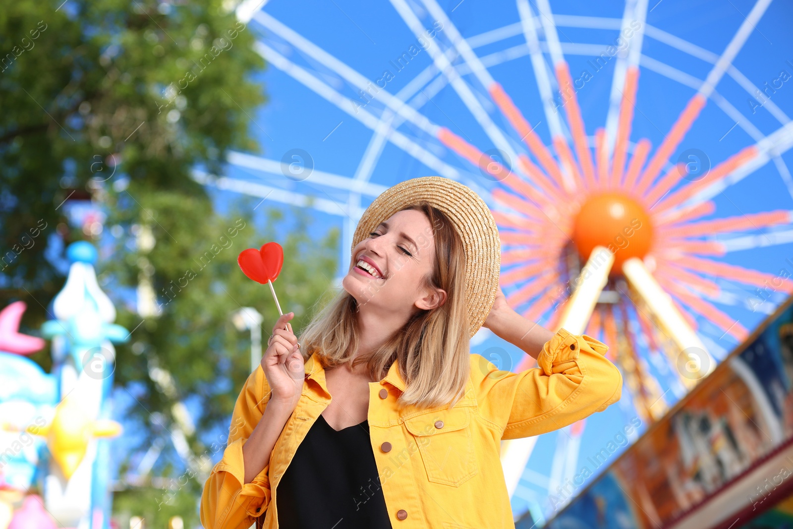 Photo of Beautiful woman with candy having fun at amusement park