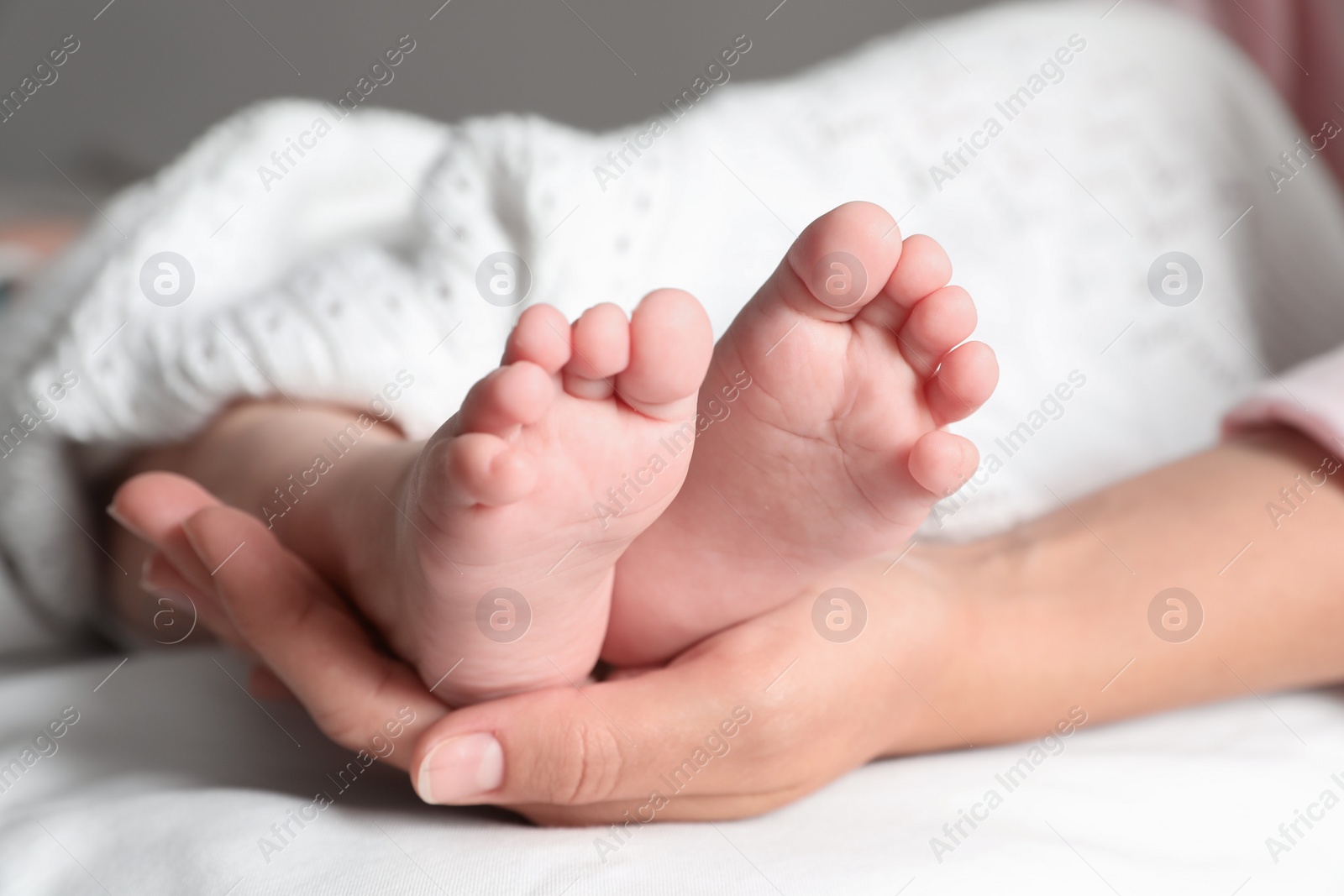 Photo of Mother holding her baby, closeup on feet