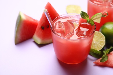 Photo of Tasty watermelon drink on violet background, closeup. Space for text