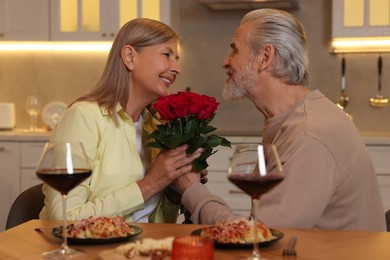 Affectionate senior couple having romantic dinner at home