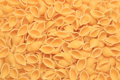 Photo of Raw conchiglie pasta as background, top view