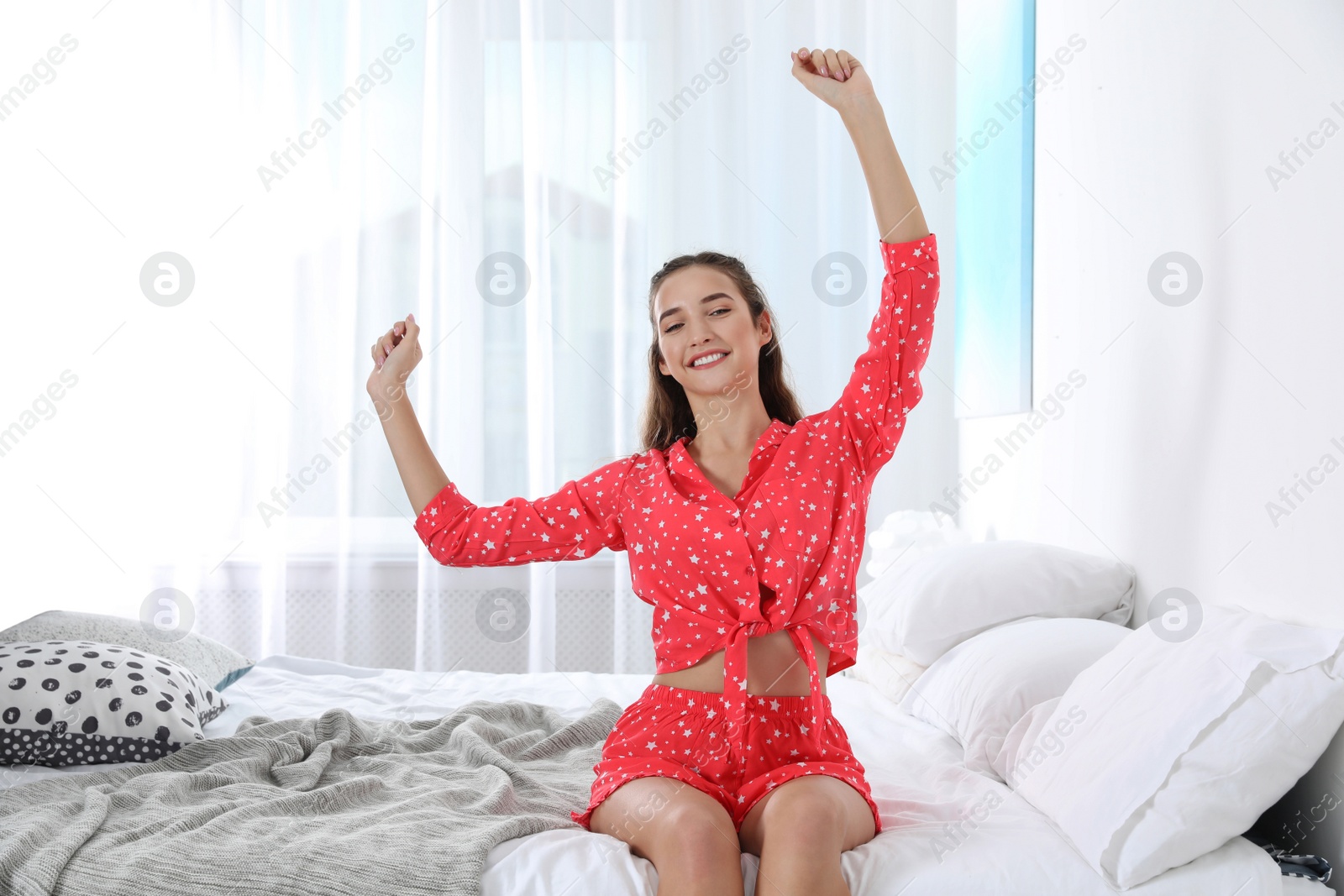 Photo of Young woman stretching on bed at home. Morning fitness