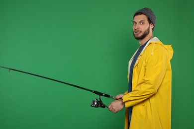 Fisherman with fishing rod on green background, space for text