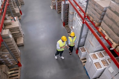Image of Manager and worker at warehouse, above view. Logistics center