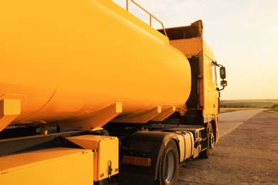 Photo of Modern yellow truck parked on country road