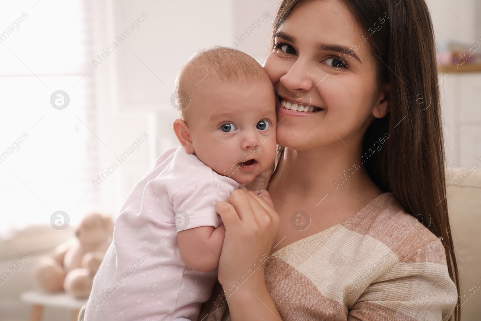 Photo of Happy young mother with her cute baby at home