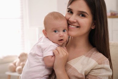 Happy young mother with her cute baby at home