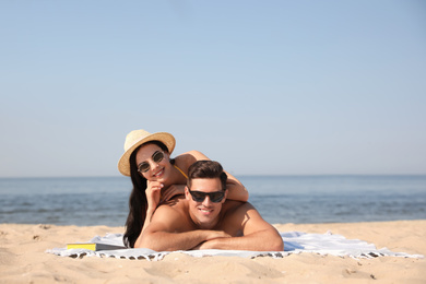 Photo of Happy couple resting on sunny beach at resort