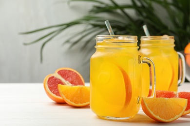 Photo of Delicious orange soda water on white wooden table. Space for text