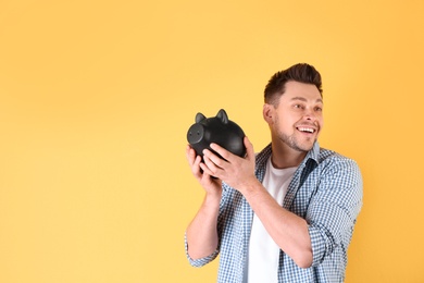 Man with piggy bank on color background. Space for text