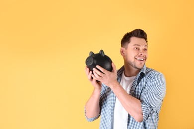 Photo of Man with piggy bank on color background. Space for text