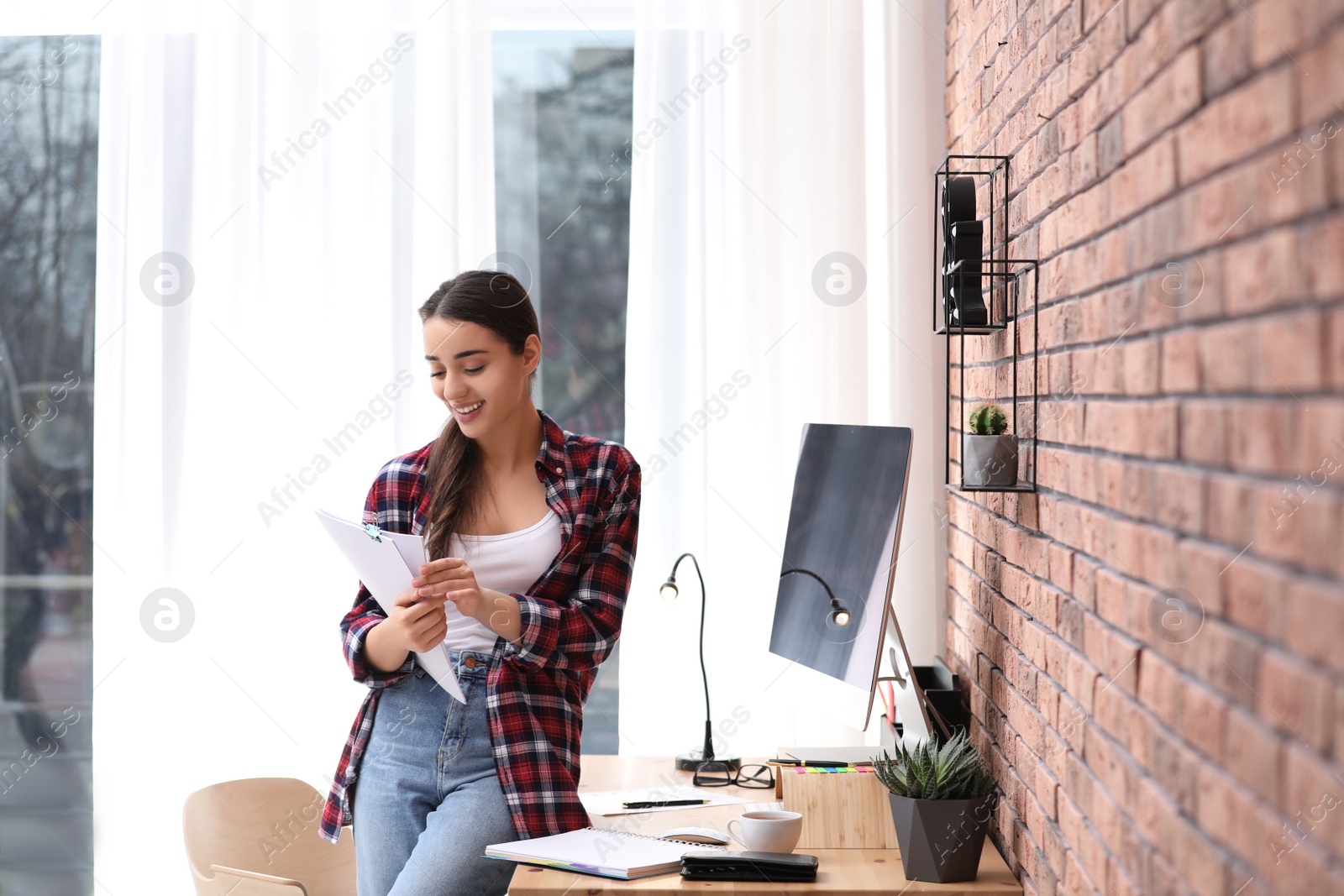 Photo of Professional journalist with papers at workplace in light office