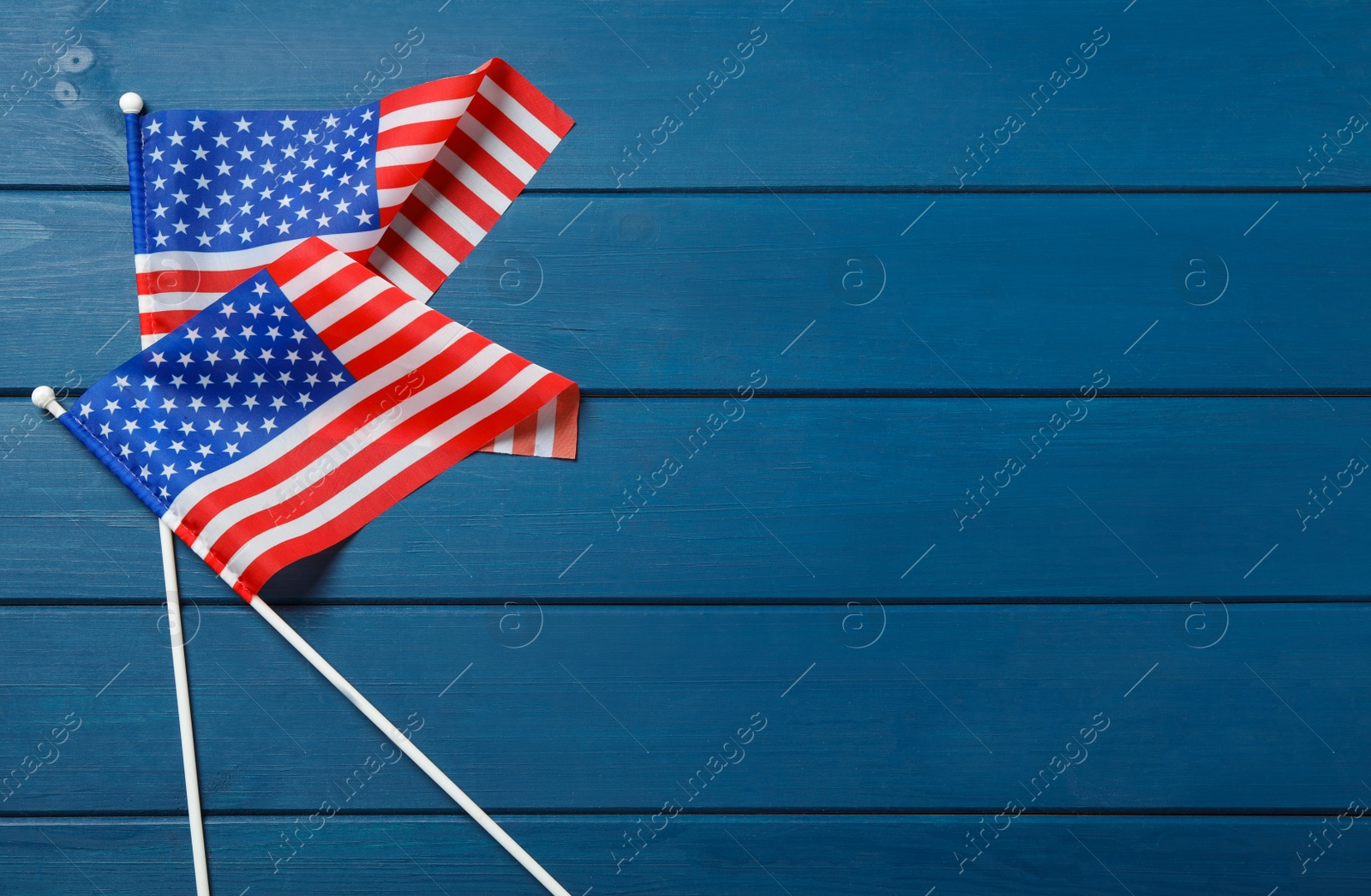 Photo of American flags on blue wooden table, flat lay with space for text. Memorial Day