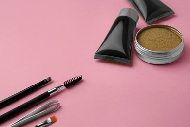 Photo of Eyebrow henna and tools on pink background