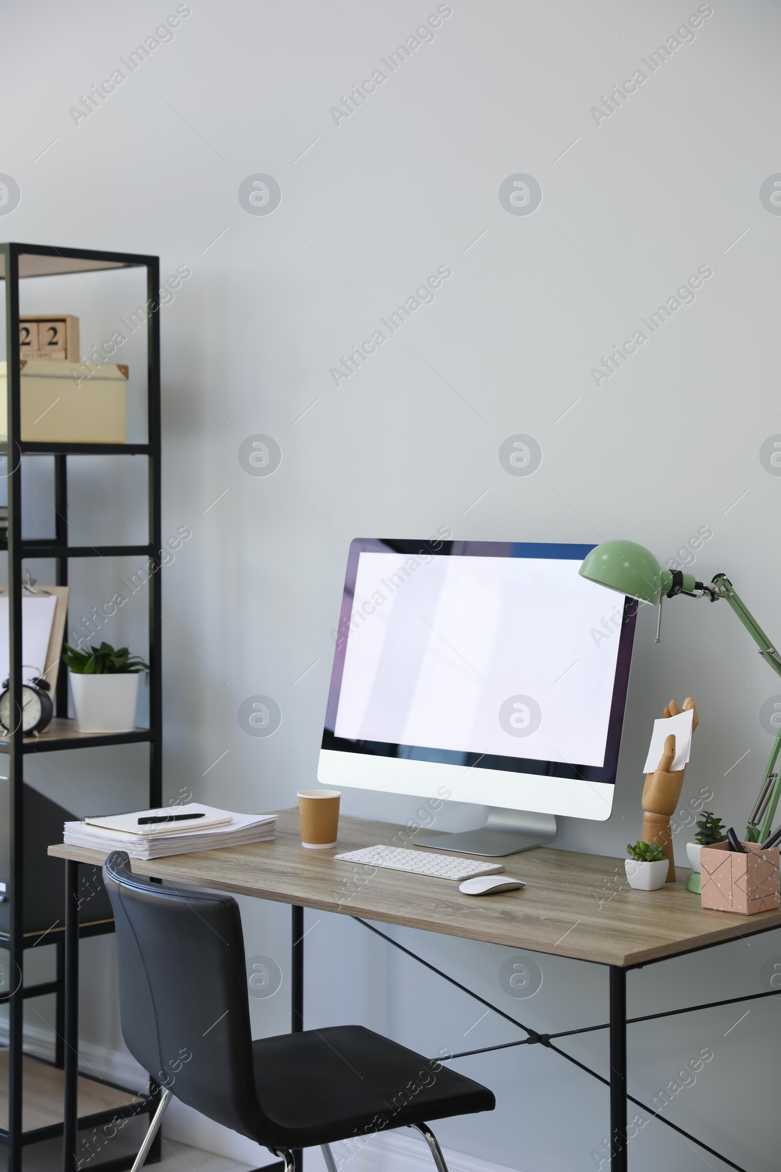 Photo of Comfortable office chair near desk with modern computer indoors