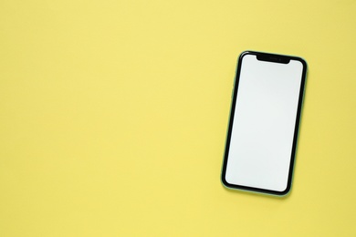 Photo of MYKOLAIV, UKRAINE - JULY 07, 2020: iPhone 11 on yellow background, top view. Mockup for design