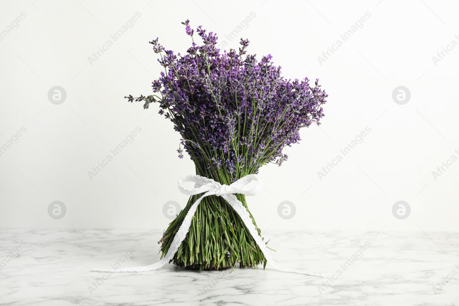 Photo of Beautiful lavender bouquet on marble table against white background
