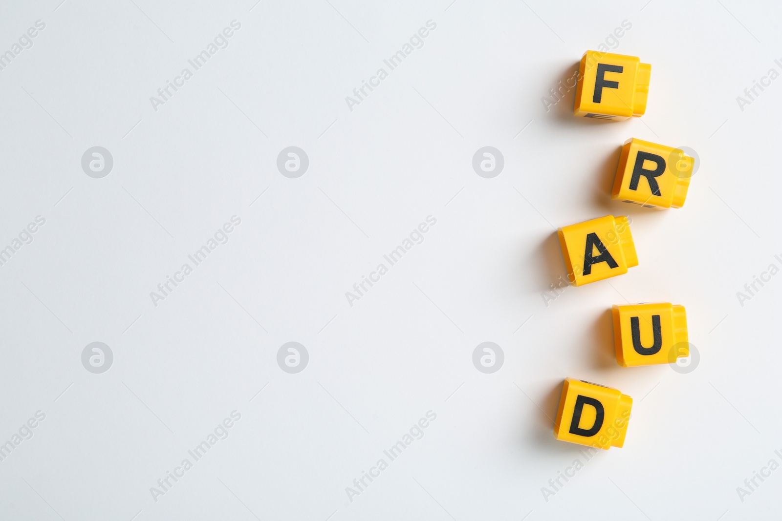 Photo of Word Fraud of yellow cubes with letters on white background, top view. Space for text