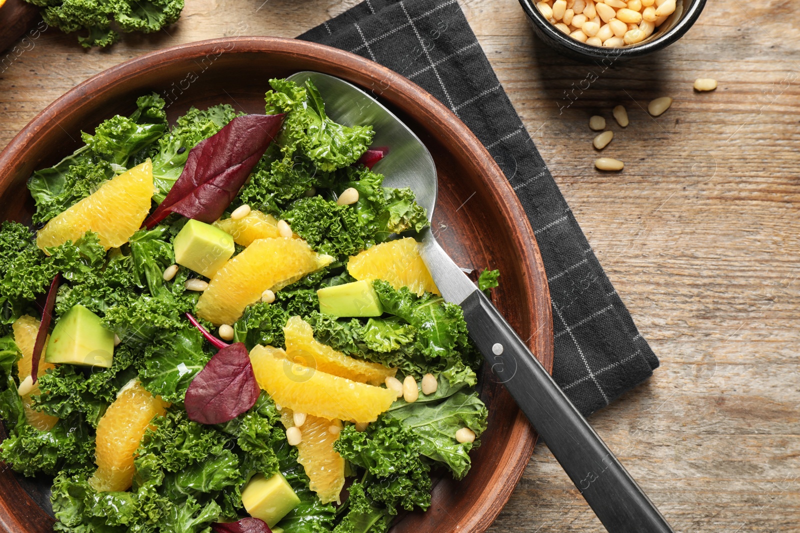 Photo of Tasty fresh kale salad on wooden table, flat lay