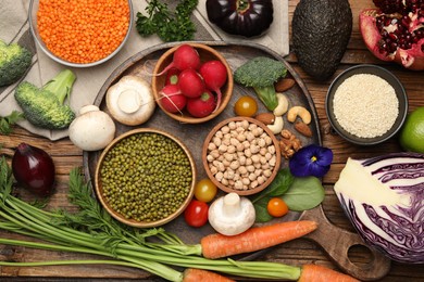 Photo of Different vegetables on wooden table, flat lay. Vegan diet