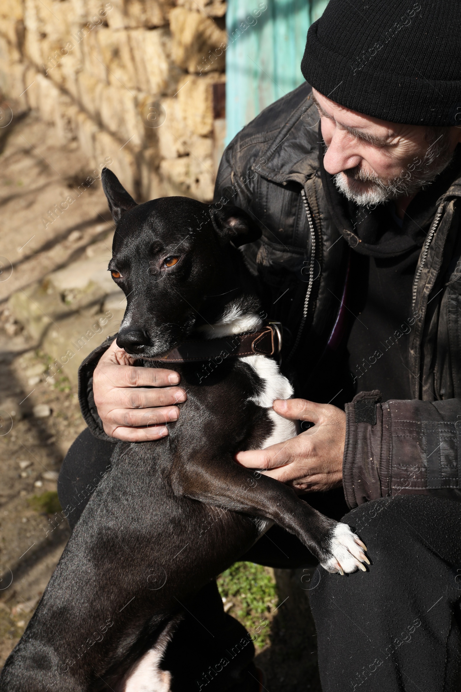 Photo of Poor homeless senior man with stray dog outdoors