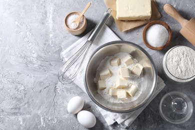 Photo of Making shortcrust pastry. Whisk, rolling pin and different ingredients for dough on grey table, flat lay. Space for text