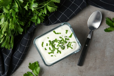 Photo of Flat lay composition with sour cream and parsley on grey table