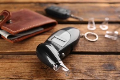 Photo of Modern breathalyzer with mouthpiece on wooden table