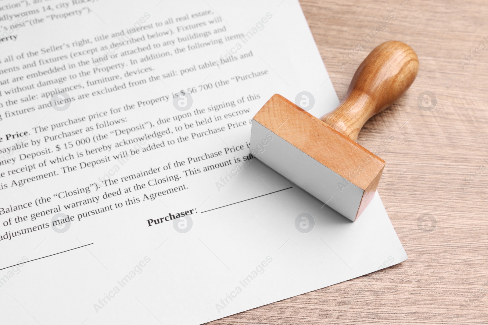 Photo of One stamp tool and document on wooden table, closeup