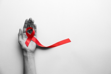 Image of World AIDS disease day. Woman holding red awareness ribbon on white background, top view with space for text