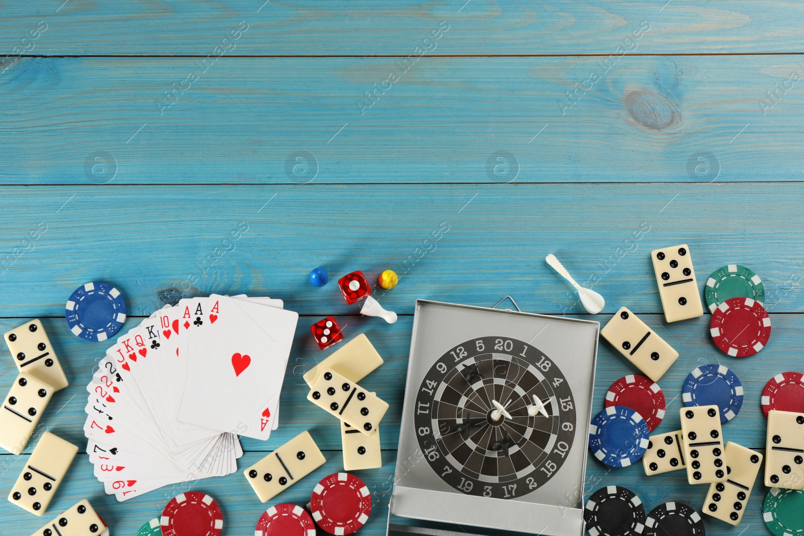 Photo of Elements of different board games on light blue wooden table, flat lay. Space for text