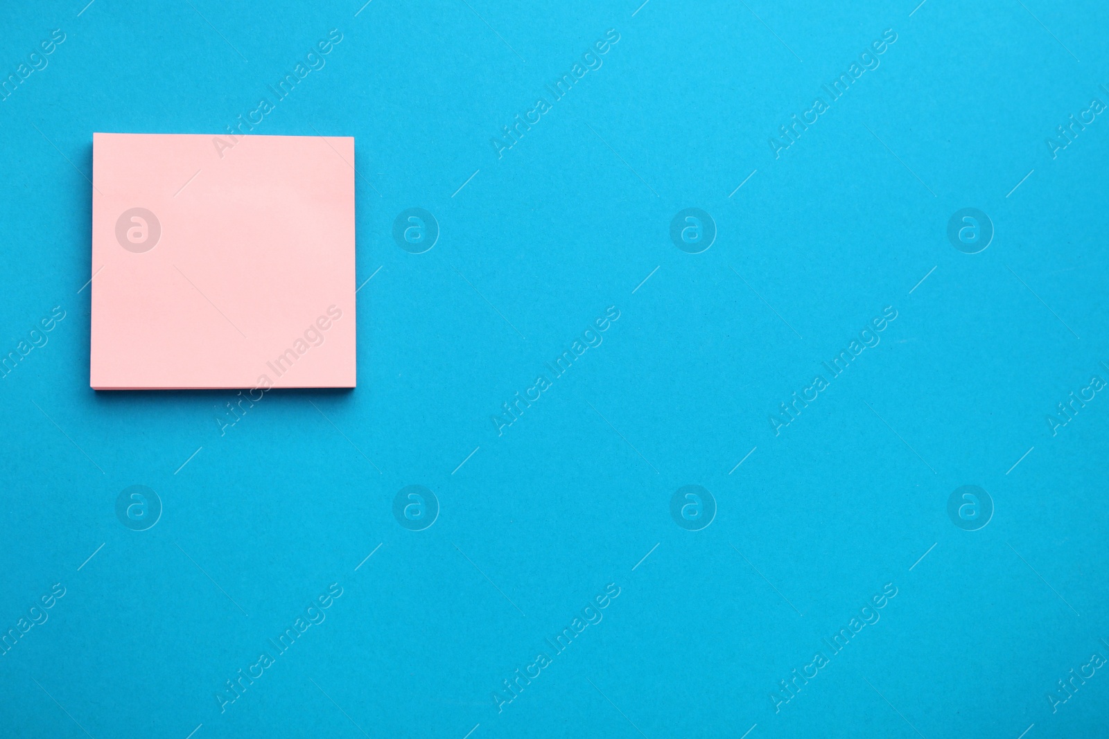 Photo of Paper note on blue background, top view. Space for text