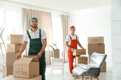 Male movers with boxes in new house