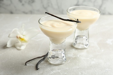 Photo of Vanilla pudding, sticks and flower on table