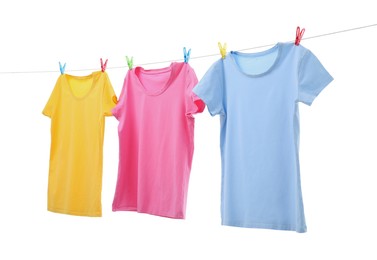 Colorful t-shirts drying on washing line isolated on white