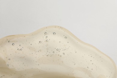Photo of Sample of cosmetic oil on beige background, closeup