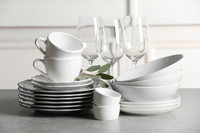 Photo of Set of clean dishes on table against blurred background