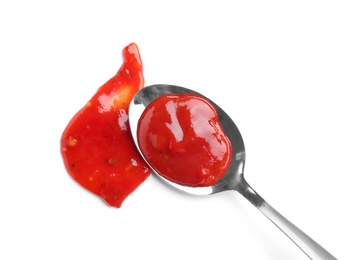 Metal spoon and red sauce on white background, top view