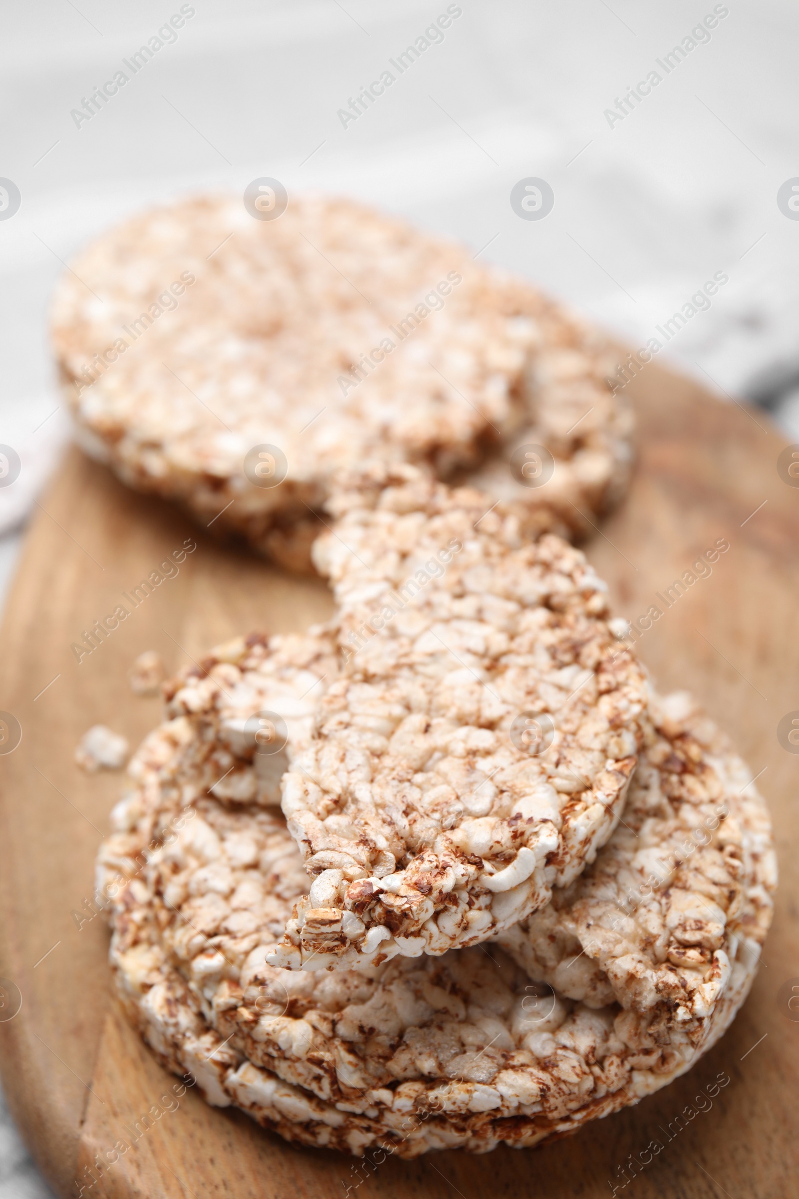 Photo of Crunchy buckwheat cakes on wooden board, closeup