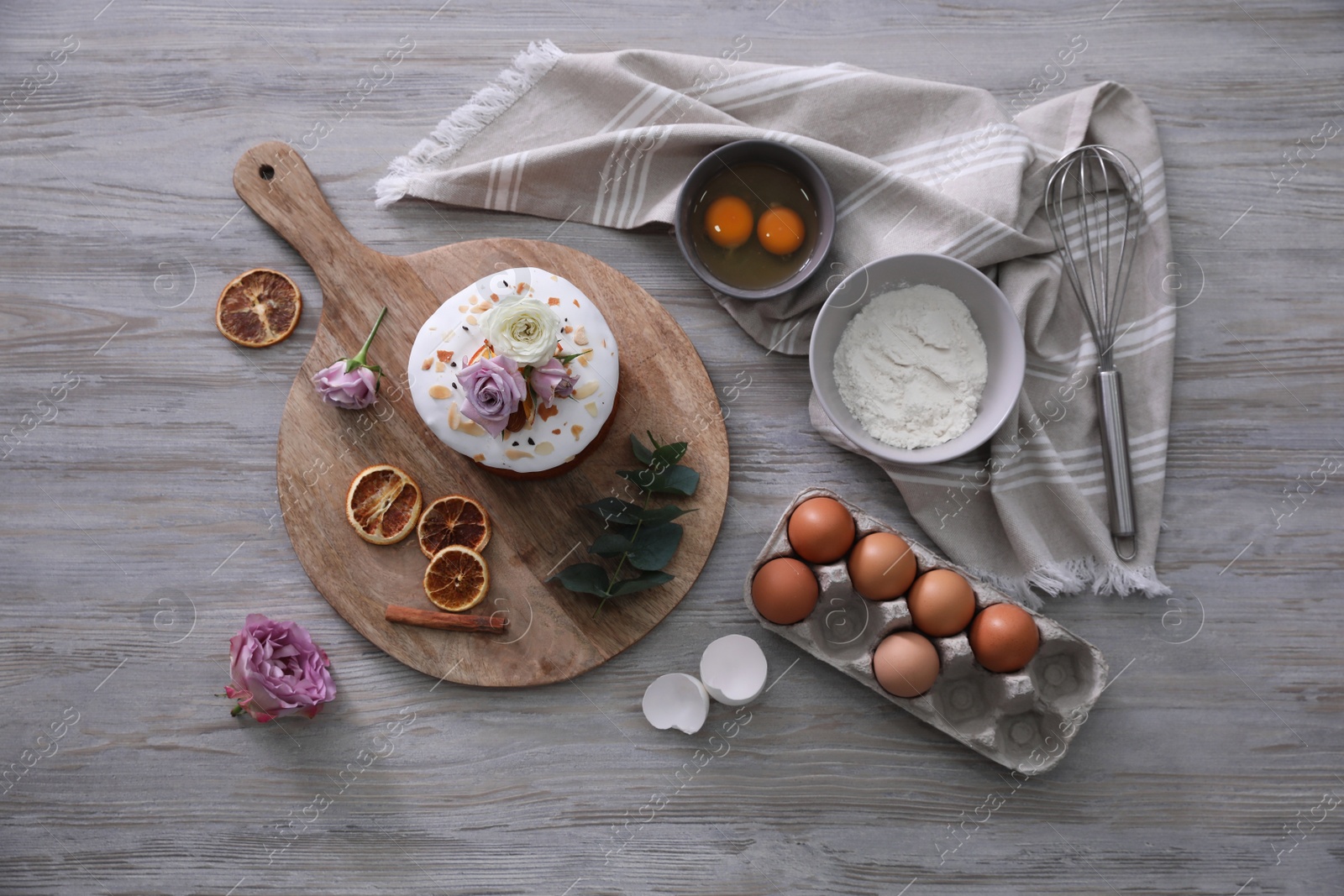 Photo of Flat lay composition with Easter cake and ingredients on light grey wooden table