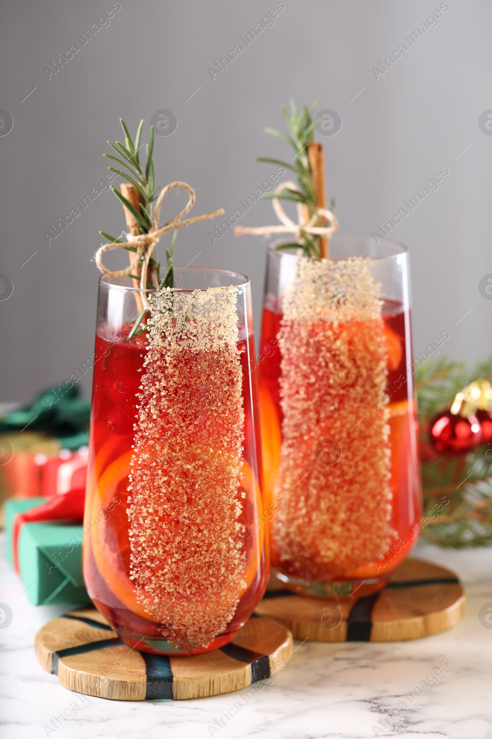 Photo of Christmas Sangria cocktail in glasses on white marble table