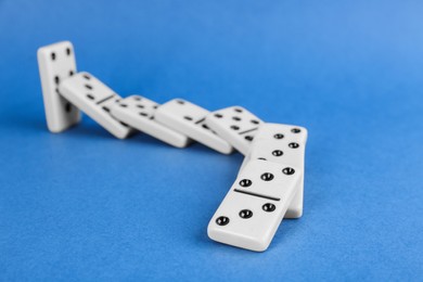 White domino tiles falling on blue background