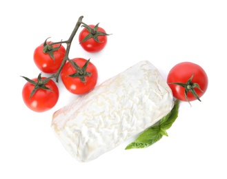 Delicious fresh goat cheese with basil and cherry tomatoes on white background, top view