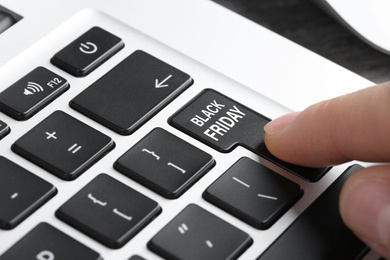 Image of Woman pressing Black Friday button on laptop keyboard, closeup. Online shopping