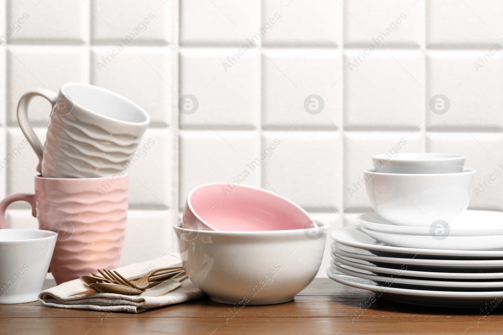 Photo of Beautiful ceramic dishware, cups and cutlery on wooden table