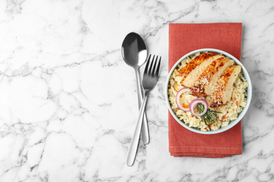 Photo of Delicious chicken risotto served on white marble table, flat lay. Space for text