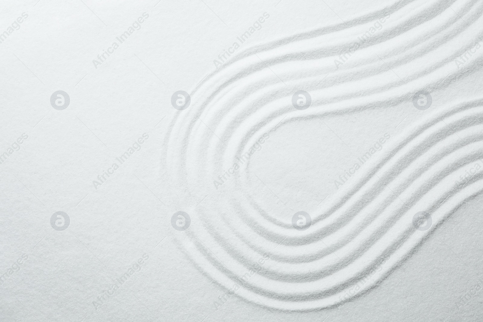 Photo of White sand with pattern as background, top view. Zen, meditation, harmony